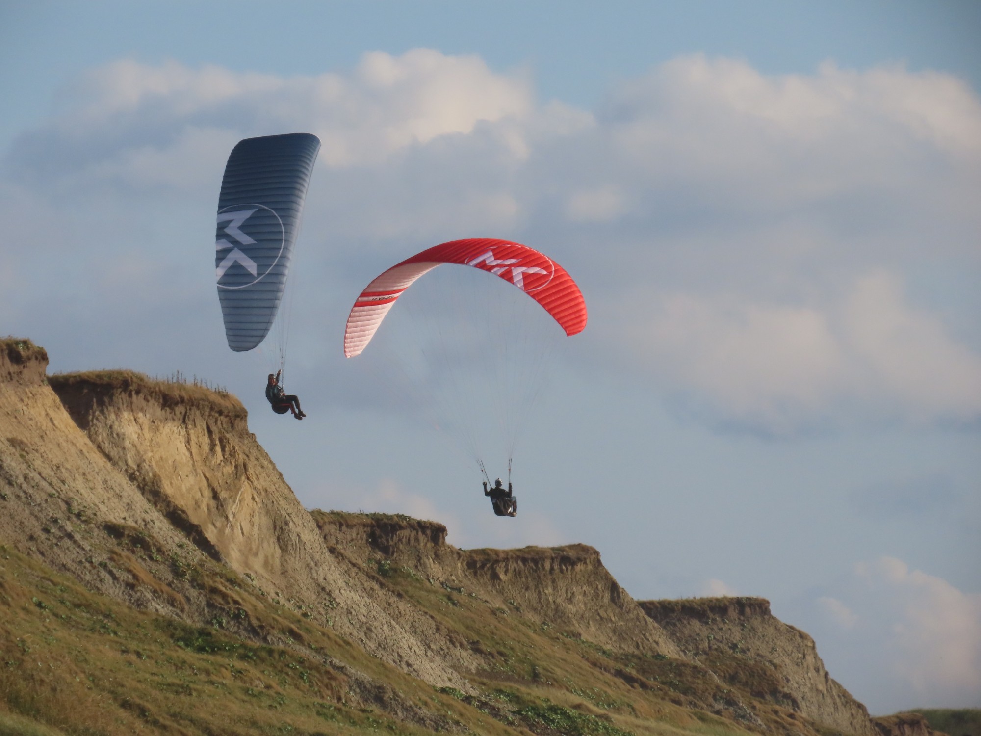 Two pilots with their SUPRAs in the air over the cliffs of Nørre Lyngby, Denmark