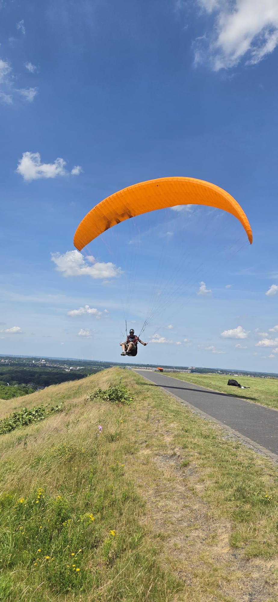 Pilot over a slag heap in the Ruhr area with an orange wing
